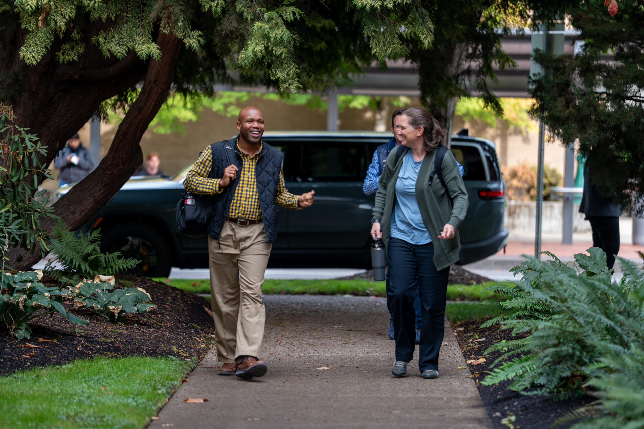 Two people walking towards the viewer engaged in conversation